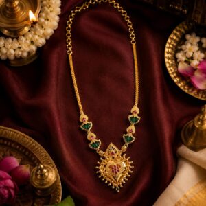 Shanku Palakka necklace gold temple jewellery close-up with jasmine and brass lamp